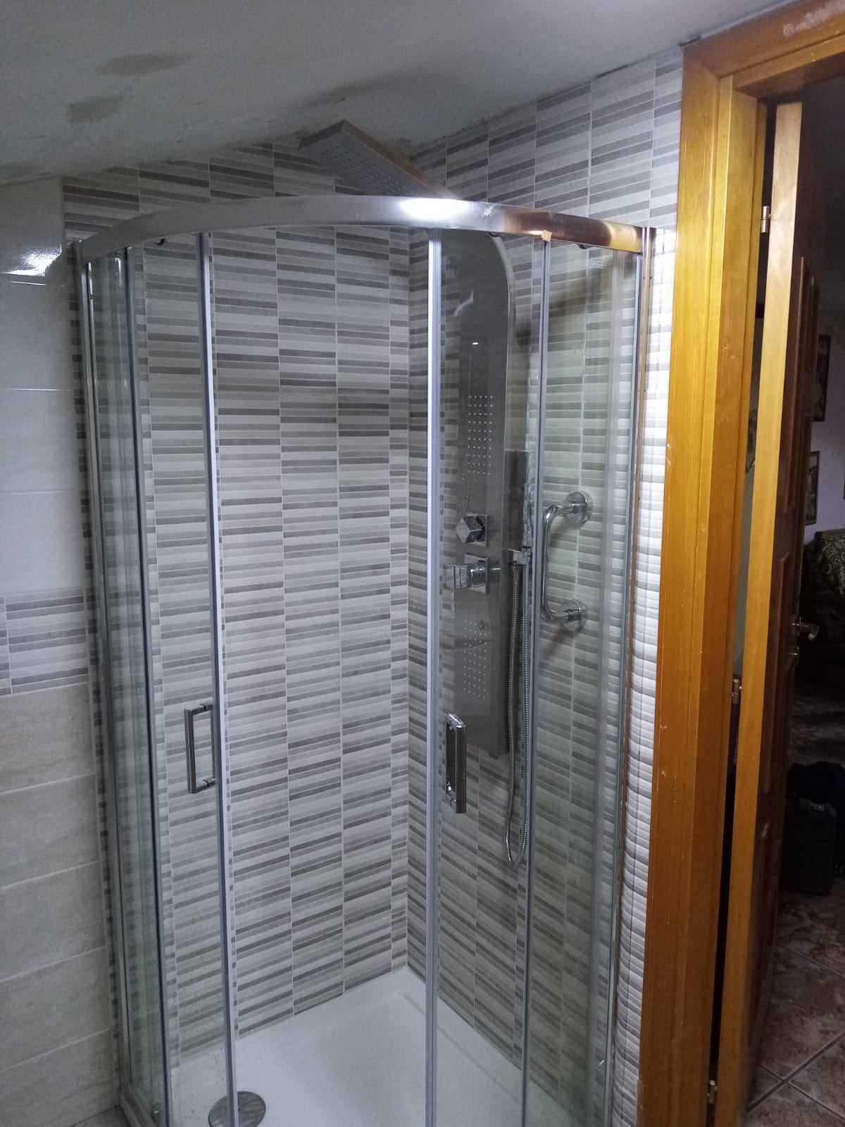 Bagno moderno con doccia e rivestimenti scuri di pregio